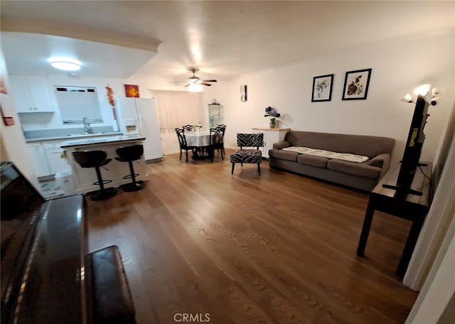 living room featuring wood-type flooring and ceiling fan