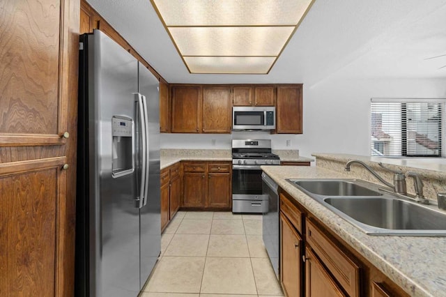 kitchen with sink, light tile patterned floors, and stainless steel appliances