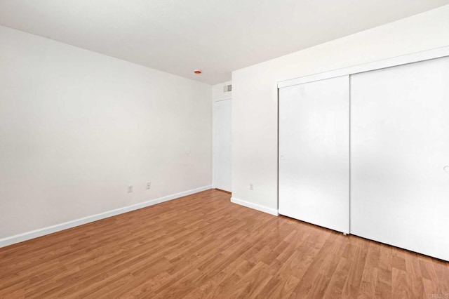 unfurnished bedroom with a closet and light hardwood / wood-style flooring