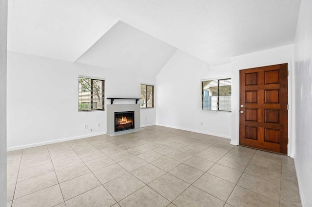 unfurnished living room featuring vaulted ceiling and light tile patterned flooring