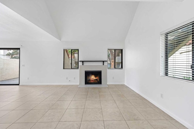 unfurnished living room with a healthy amount of sunlight, high vaulted ceiling, and light tile patterned floors