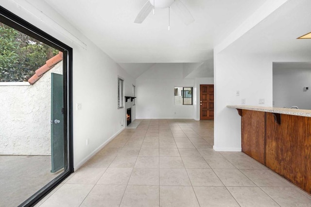 hallway with vaulted ceiling and light tile patterned floors