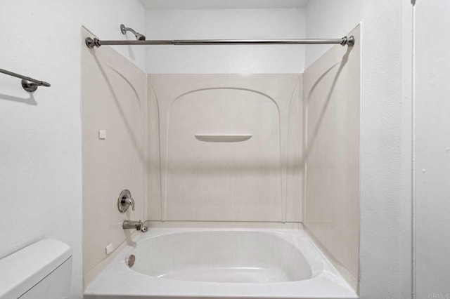 bathroom featuring shower / washtub combination and toilet