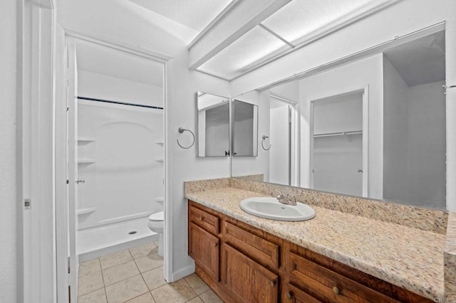 bathroom with vanity, toilet, tile patterned floors, and walk in shower