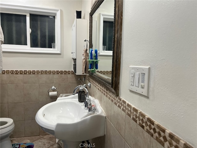 bathroom with sink, tile walls, tile patterned floors, and toilet