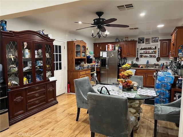 dining area featuring visible vents, light wood-style floors, and ceiling fan