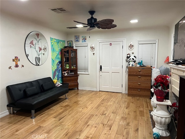 living area with light hardwood / wood-style floors and ceiling fan