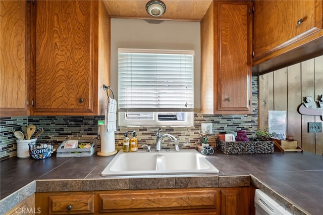 kitchen featuring dishwashing machine, sink, and tasteful backsplash