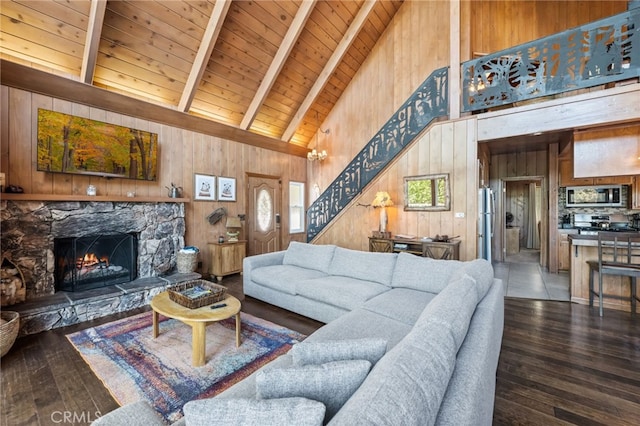 living room featuring dark hardwood / wood-style floors, a fireplace, wood walls, beamed ceiling, and wood ceiling