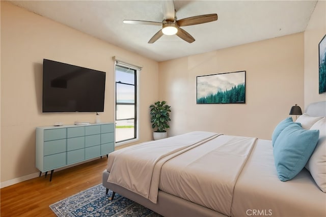 bedroom featuring a ceiling fan, baseboards, and light wood-type flooring