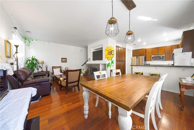 dining room featuring a fireplace and dark hardwood / wood-style flooring