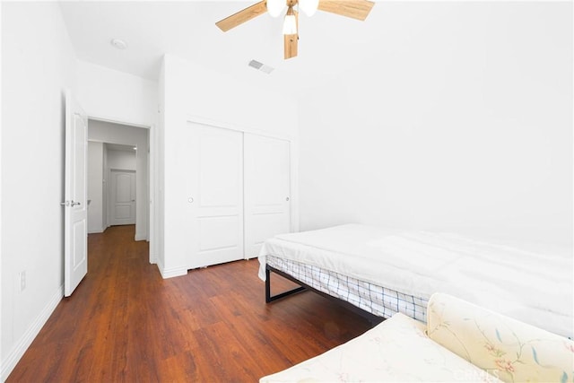 bedroom featuring dark wood-type flooring, ceiling fan, and a closet