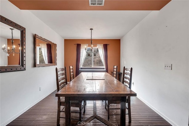 dining area with dark hardwood / wood-style floors and a chandelier