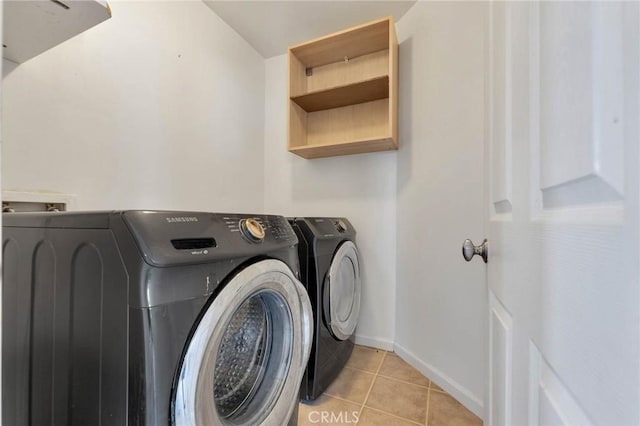 laundry area featuring washing machine and dryer and light tile patterned floors