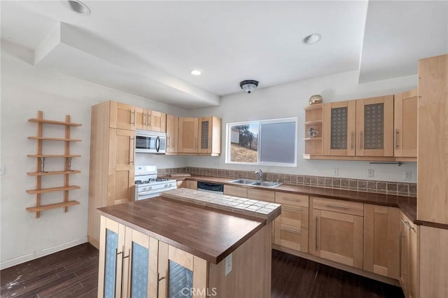 kitchen featuring sink, appliances with stainless steel finishes, a kitchen island, dark hardwood / wood-style flooring, and light brown cabinets