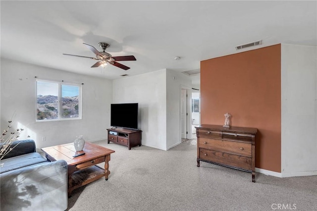 carpeted living room with ceiling fan