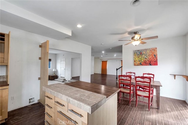 kitchen featuring ceiling fan, dark wood-type flooring, tile countertops, and light brown cabinetry