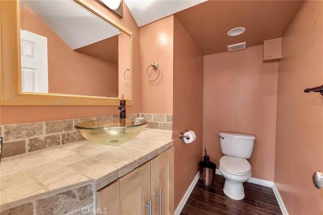 bathroom featuring vanity, toilet, and wood-type flooring