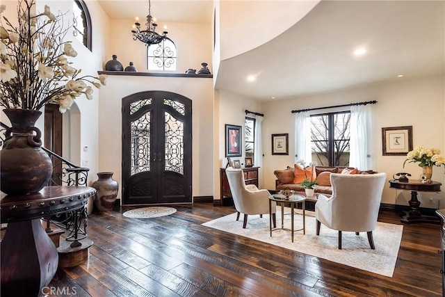 foyer entrance featuring an inviting chandelier, dark hardwood / wood-style floors, and french doors