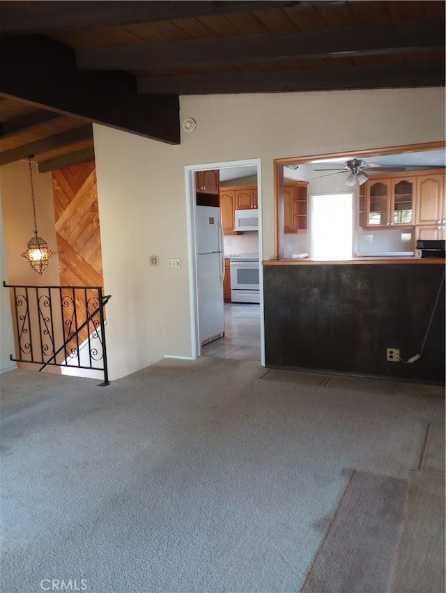 unfurnished living room featuring vaulted ceiling with beams, wood ceiling, ceiling fan, and carpet flooring