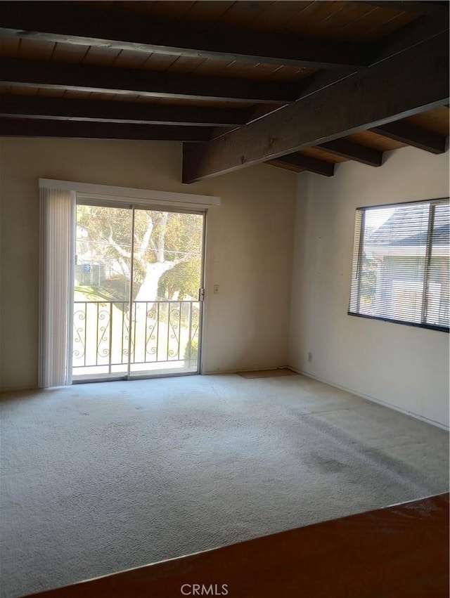 carpeted empty room featuring wood ceiling and lofted ceiling with beams