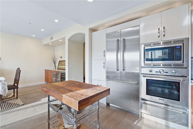 kitchen with visible vents, baseboards, built in appliances, a warming drawer, and recessed lighting