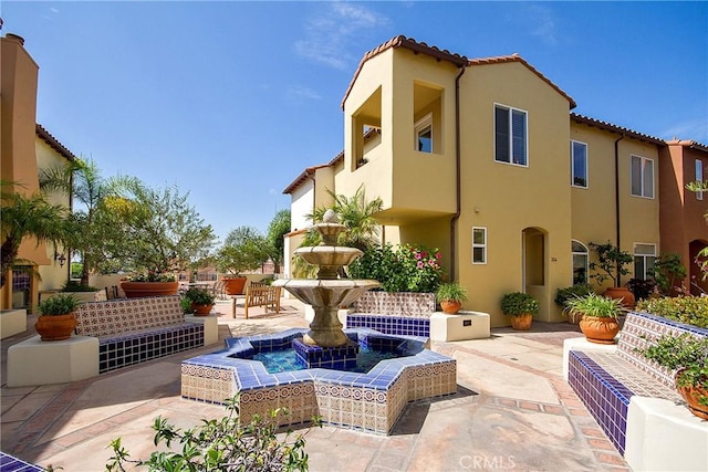 exterior space featuring a patio area, a tile roof, and stucco siding