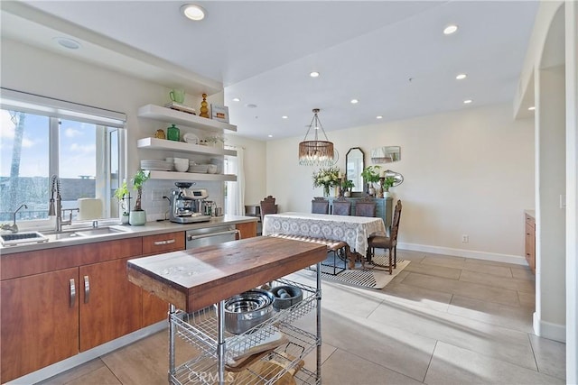 kitchen with light tile patterned flooring, sink, an inviting chandelier, decorative light fixtures, and stainless steel dishwasher