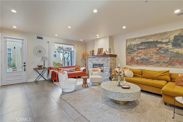 living room with recessed lighting, visible vents, a fireplace, and baseboards