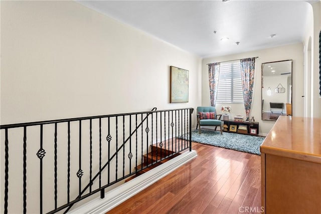 hallway with hardwood / wood-style flooring and an upstairs landing