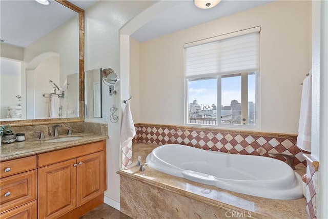 bathroom featuring vanity and tiled bath