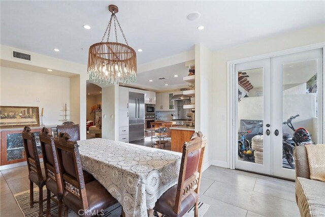 dining area featuring light tile patterned floors, french doors, and a chandelier