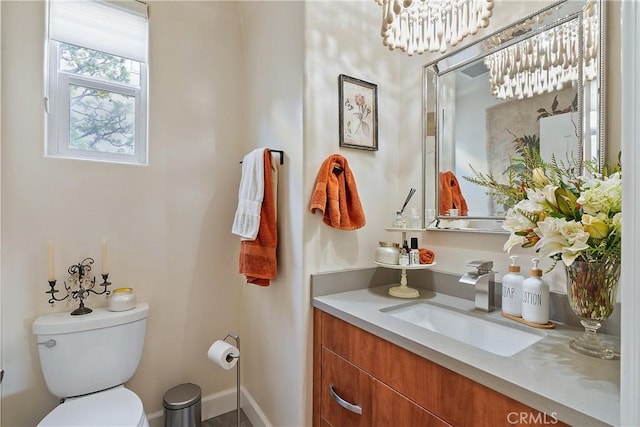 bathroom featuring baseboards, vanity, and toilet