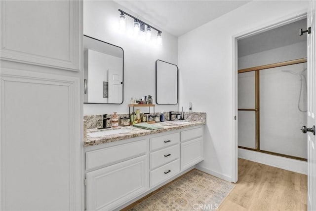 bathroom with vanity, hardwood / wood-style flooring, and walk in shower