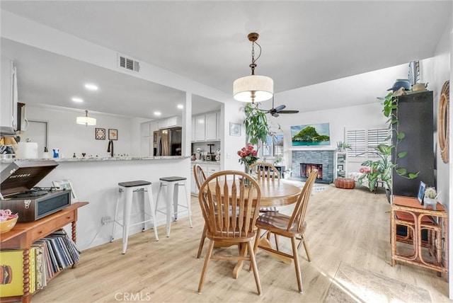 dining room featuring a fireplace and light hardwood / wood-style floors