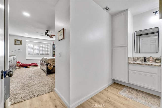 bathroom featuring ceiling fan, wood-type flooring, and vanity