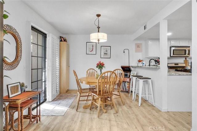 dining room with sink and light hardwood / wood-style floors