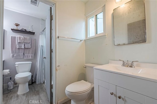 bathroom with vanity, hardwood / wood-style floors, a shower with shower curtain, and toilet