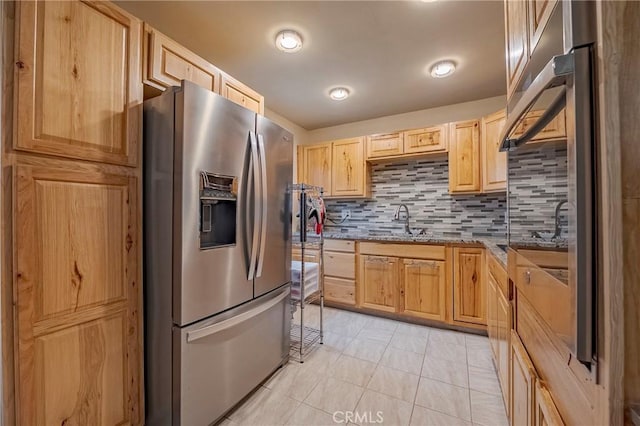 kitchen featuring sink, backsplash, light stone countertops, light brown cabinetry, and stainless steel fridge with ice dispenser