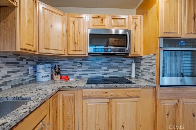 kitchen with light brown cabinetry, sink, appliances with stainless steel finishes, light stone countertops, and backsplash