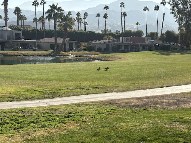 view of community with a water and mountain view and a lawn