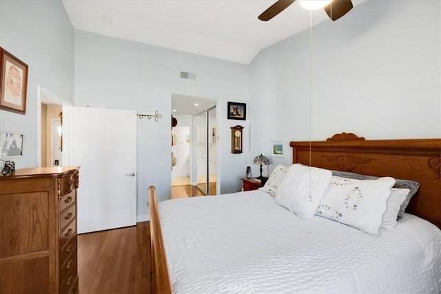 bedroom with vaulted ceiling, dark hardwood / wood-style floors, connected bathroom, and ceiling fan