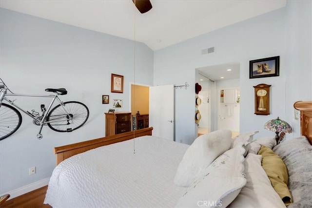 bedroom featuring vaulted ceiling, hardwood / wood-style floors, and ceiling fan