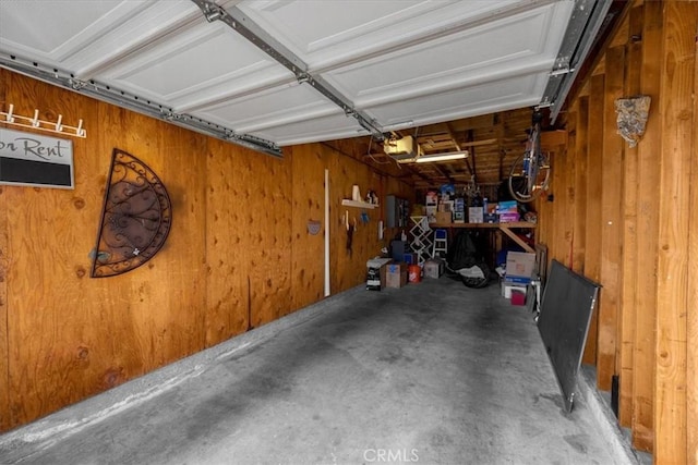 garage with a garage door opener and wooden walls