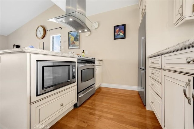 kitchen with appliances with stainless steel finishes, light stone countertops, white cabinets, island exhaust hood, and light wood-type flooring