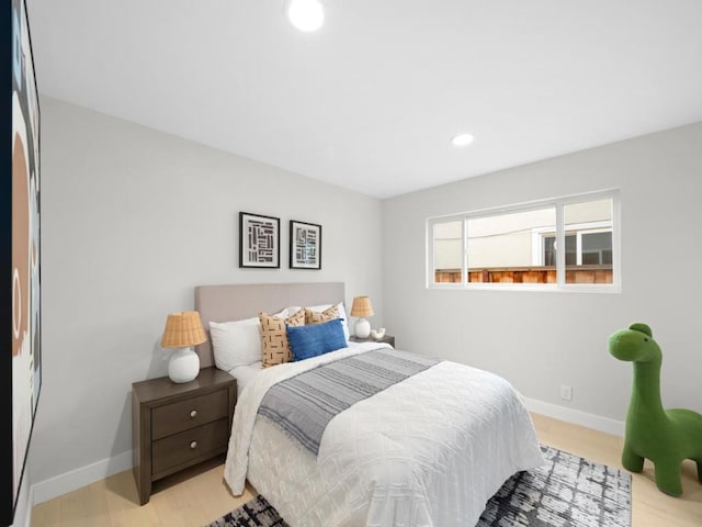 bedroom with fridge and light hardwood / wood-style flooring