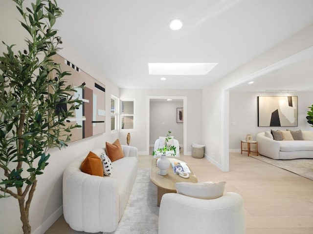 living room with a skylight and light hardwood / wood-style floors