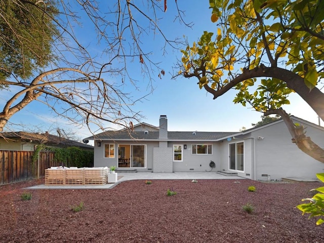 back of house with an outdoor living space and a patio