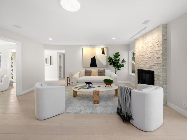 living room featuring rail lighting and a fireplace