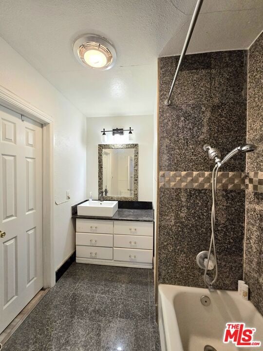 bathroom with vanity and tiled shower / bath combo